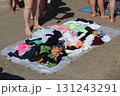 Beachgoers are browsing colorful pareos at an outdoor market on a sunny summer day 131243291