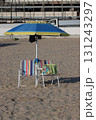 Beach umbrella and chairs standing on sandy beach near construction site 131243297