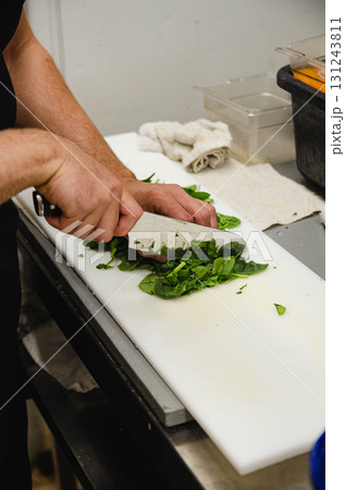 Fresh Spinach Being Chopped on Cutting Board 131243811