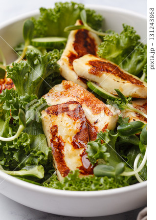 Cucumbers, sprouts and green leaves salad with fried halloumi. 131243868