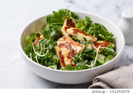 Cucumbers, sprouts and green leaves salad with fried halloumi. 131243870