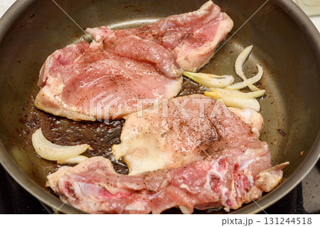 Marinated meat is fried with onions and vegetable oil in a frying pan. Marinated meat is fried with onions and vegetable oil in a frying pan. 131244518