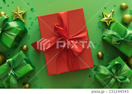Red and Green Christmas Gift Boxes with Ornaments on Green Background 131244543