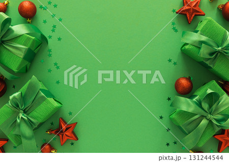 Green Gift Boxes with Red Ornaments and Star Confetti on Festive Background Green Gift Boxes with Red Ornaments and Star Confetti on Festive Background 131244544