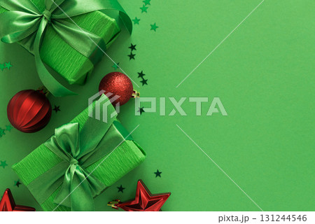 Green Gift Boxes with Red Ornaments and Star Confetti on Festive Background Green Gift Boxes with Red Ornaments and Star Confetti on Festive Background 131244546