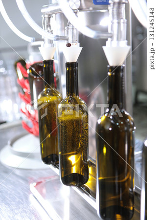 Empty bottles on wine production line. Wine of new harvest is bottled. Small author's winery.Vertical photo. Empty bottles on wine production line. Wine of new harvest is bottled. Small author's winery.Vertical photo. 131245148
