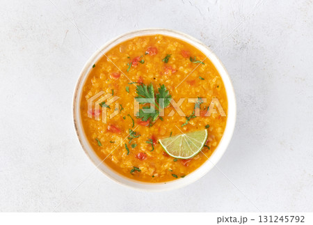 Red lentil soup with spices and fresh herbs on a gray background. Indian dal soup. Top view 131245792