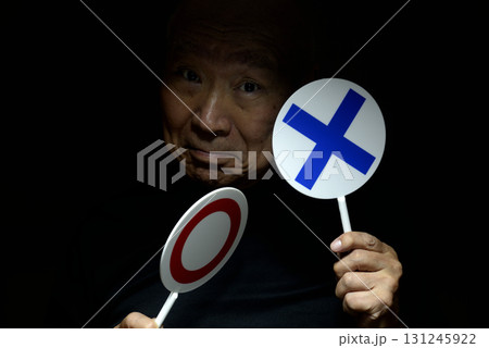 老人の手に　マル　バツ　プラカード 131245922