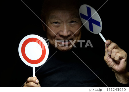 老人の手に　マル　バツ　プラカード 131245930