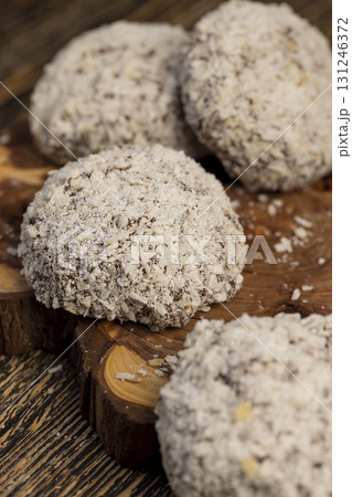 whole half sweet marshmallows in chocolate sprinkled with coconut chips, sweet dessert marshmallows in milk chocolate with coconut 131246372