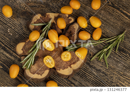 fresh sweet kumquat cut into halves close up, sliced orange kumquat fruits lie on the table during cooking 131246377