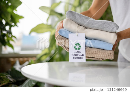 Sustainable fashion concept with folded eco-friendly clothes and recycling tag 131246669