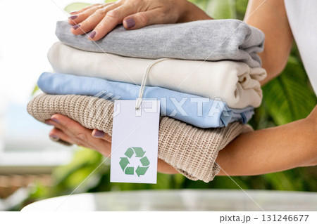 Sustainable fashion concept with folded eco friendly clothes and recycling tag Sustainable fashion concept with folded eco friendly clothes and recycling tag 131246677