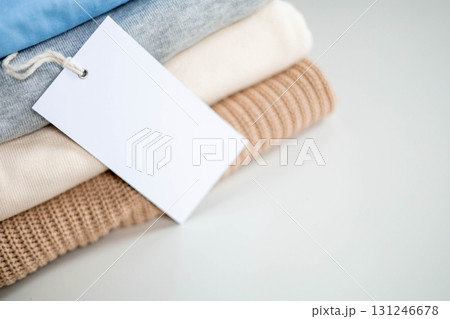 Stack of folded clothes with blank recycled label tag for eco-friendly and sustainable fashion 131246678