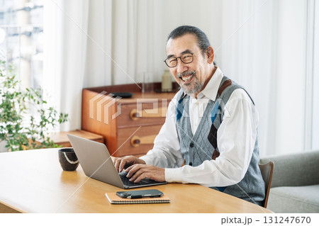 家のリビングでパソコン作業をするシニア男性のポートレート 131247670