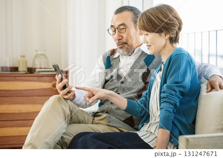 家のリビングで一緒にスマホを見るシニア夫婦 131247671
