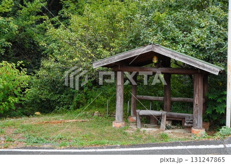 山の中の道路脇に建てられた木製の小さな屋根付き休憩所とベンチの風景写真 131247865