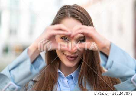 Smiling woman making heart shape with hands during Smiling woman making heart shape with hands during 131247875