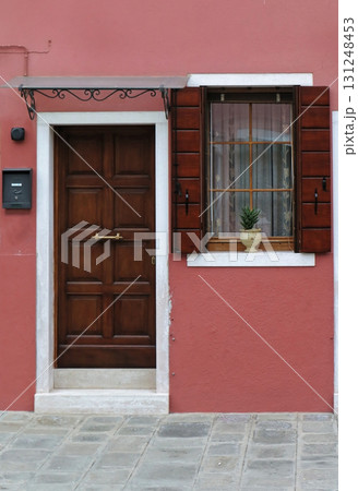 Brown door on pink facade 131248453