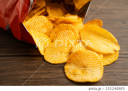 Potato chips, delicious BBQ seasoning spicy for crips, thin slice deep fried snack fast food in open bag. Potato chips, delicious BBQ seasoning spicy for crips, thin slice deep fried snack fast food in open bag. 131248983