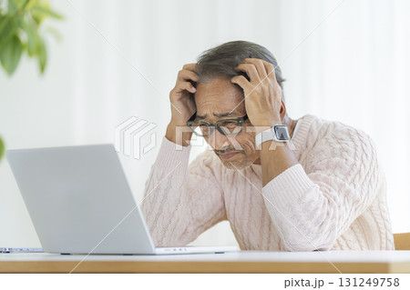 ノートパソコンの前で頭を抱える60代の男性 ノートパソコンの前で頭を抱える60代の男性 131249758