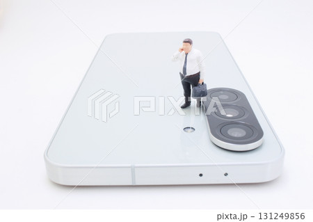 Businessman Figurine On Modern Smartphone With Triple Camera 131249856