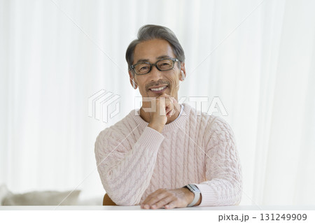 カメラ目線で笑顔のイヤホンをつけた60代の男性 131249909
