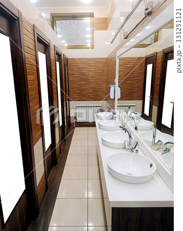 interior of a public restroom with wooden doors, ceramic sinks and faucets interior of a public restroom with wooden doors, ceramic sinks and faucets 131251121