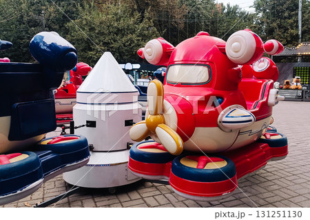 children's carousel shaped like an airplane with a propeller and wings in a city park. children's carousel shaped like an airplane with a propeller and wings in a city park. 131251130