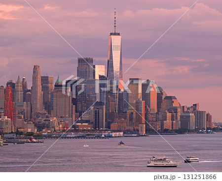 Lower Manhattan illuminated at dusk with purple sky and Hudson River on a foreground 131251866