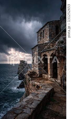Ruined monastery stone building cliff sea dramatic sky ancient moody historic 131252653