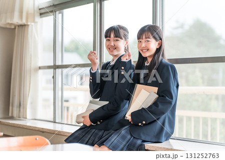学校の教室で会話する小学生,中学生の女子生徒(ガッツポーズ) 学校の教室で会話する小学生,中学生の女子生徒(ガッツポーズ) 131252763