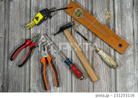 Assorted work tools lying on rustic wooden table 131253116