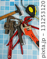 Essential plumbing tools lying on blue bathroom tiles ready for home improvement Essential plumbing tools lying on blue bathroom tiles ready for home improvement 131253120