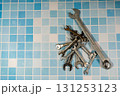 Wrenches lying on blue tiles representing plumbing and maintenance Wrenches lying on blue tiles representing plumbing and maintenance 131253123