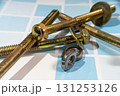 Screws, bolts, nuts and washers lying on blue tiles Screws, bolts, nuts and washers lying on blue tiles 131253126