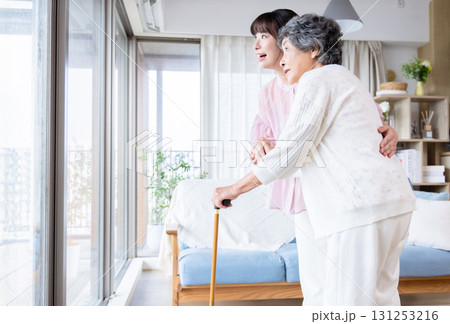 杖をつくシニア女性を介助する若い女性 杖をつくシニア女性を介助する若い女性 131253216