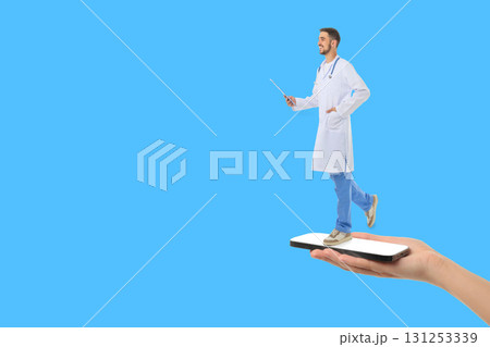 Doctor holds a pointer while standing on a smartphone in hand Doctor holds a pointer while standing on a smartphone in hand 131253339