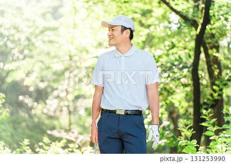 新緑の中でゴルフウェアを着た男性ゴルファー（ゴルフコース・アカデミー・会員権） 131253990