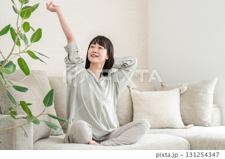 家のソファでリラックス・リフレッシュをする若いアジア人女性（モーニングルーティーン） 131254347