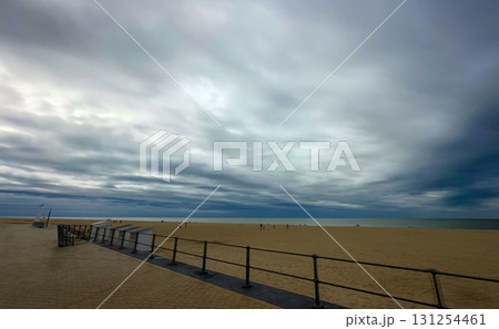 A serene and calm beach scene unfolds under dramatically beautiful clouds in the sky A serene and calm beach scene unfolds under dramatically beautiful clouds in the sky 131254461