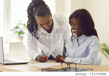 Happy woman signs a contract with a loan broker, credit advisor or real estate agent 131254896