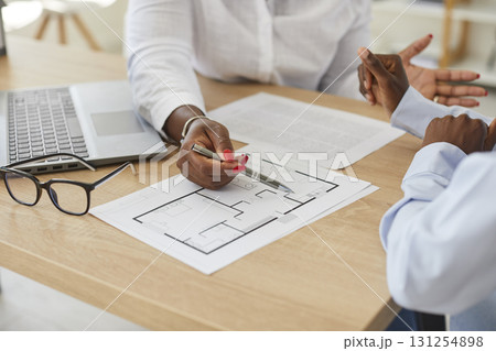 Young interior designer african american woman showing her client floor plan of new house. 131254898
