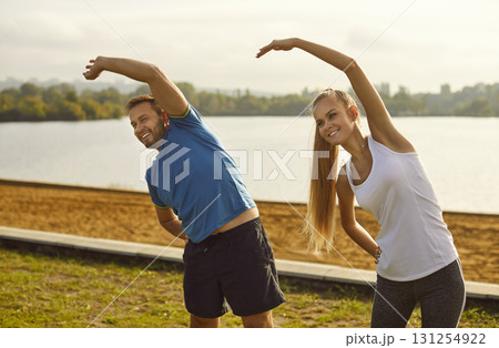Young fit and active couple doing sport exercising in nature. Outdoors fitness concept. Young fit and active couple doing sport exercising in nature. Outdoors fitness concept. 131254922