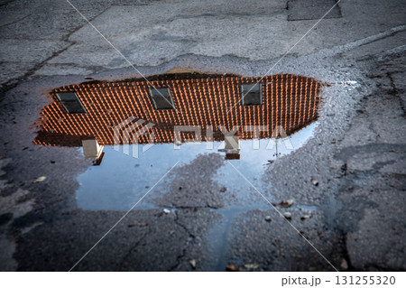 Red Roof House Reflection in Rainwater Puddle 131255320