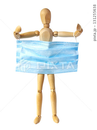 A wooden man holds a blue medical protective mask with space for text. A concept of protection during a coronavirus pandemic. Copy space. 131255638