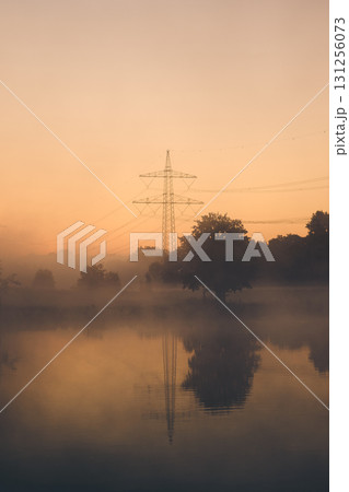 Powerline on hazy morning with reflection in lake Powerline on hazy morning with reflection in lake 131256073