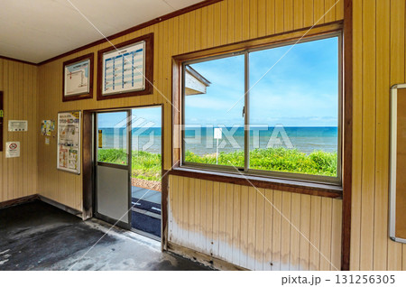 海沿いの古びた駅舎の窓から見る日本海の水平線 131256305