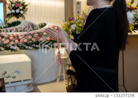葬儀場で手を合わせて拝む若い女性の手元 131257156