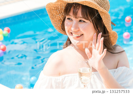プールサイドでシャンパンを飲む若いアジア人女性（リゾート・バカンス・バケーション） 131257533